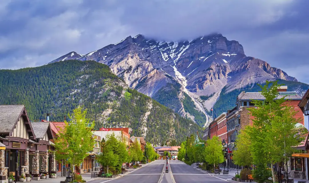 A view down a street in Banff with mountains in the background